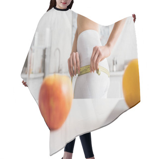Personality  Selective Focus Of Slim Girl Measuring Hips Near Fruits, Glass Of Water And Scales On Table In Kitchen, Calorie Counting Diet Hair Cutting Cape