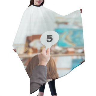 Personality  Cropped View Of Buyer Showing Auction Paddle With Number Five During Auction Hair Cutting Cape