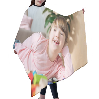 Personality  Child With Down Syndrome Lying On Floor With Toy Cubes Hair Cutting Cape