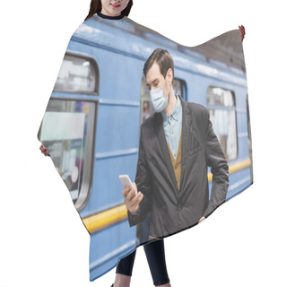 Personality  Tattooed Man In Medical Mask Holding Smartphone And Standing With Hand On Pocket Near Wagon Of Metro Hair Cutting Cape