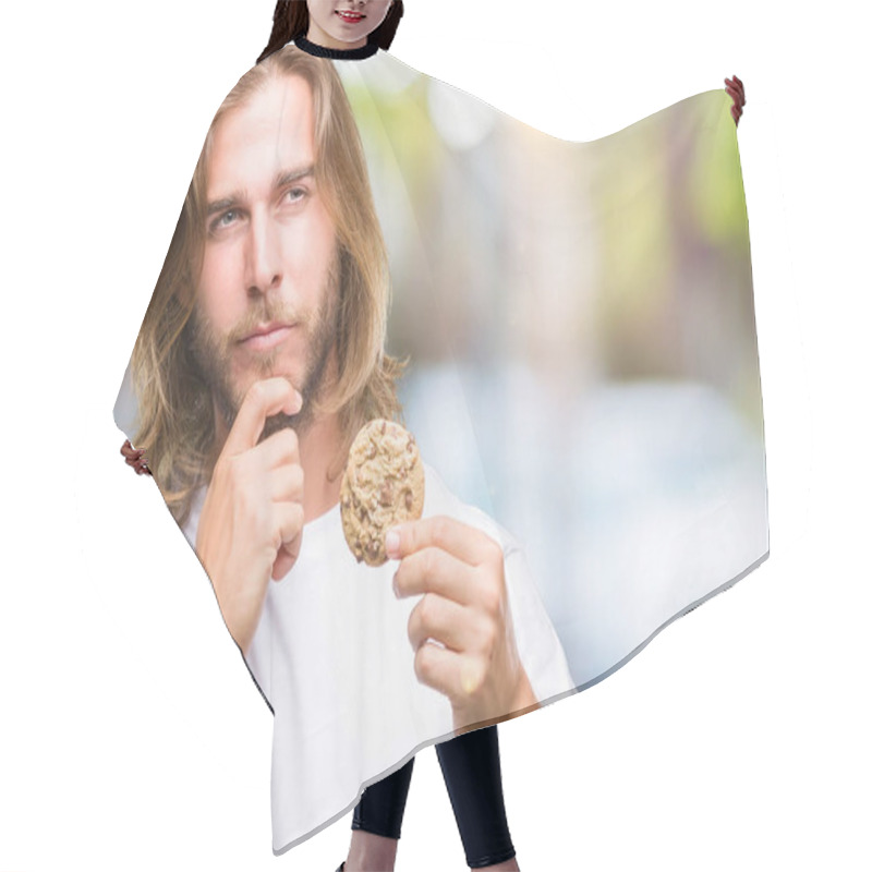 Personality  Young Handsome Man With Long Hair Eating Chocolate Cooky Over Isolated Background Serious Face Thinking About Question, Very Confused Idea Hair Cutting Cape