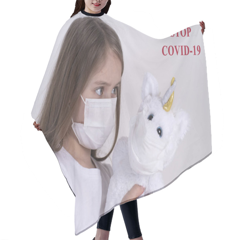 Personality  Little Sad Girl In A White T-shirt In A Protective Mask Plays With A Toy. . Wuhan Epidemic Outbreak. Dangerous Chinese Novel Virus COVID-19.The Girl Is Sad Because Of The Virus. Hair Cutting Cape