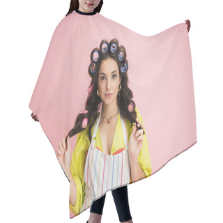 Personality  Brunette Housewife In Hair Curlers And Striped Apron Looking At Camera Isolated On Pink Hair Cutting Cape