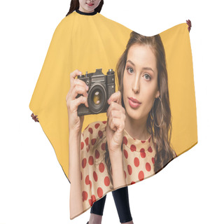 Personality  Confident Young Woman Holding Digital Camera While Looking At Camera Isolated On Yellow Hair Cutting Cape