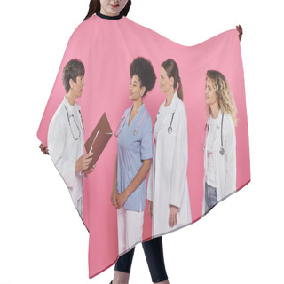 Personality  Doctor Holding Paper Folder Near Smiling Interracial Colleagues Isolated On Pink, Breast Cancer Hair Cutting Cape