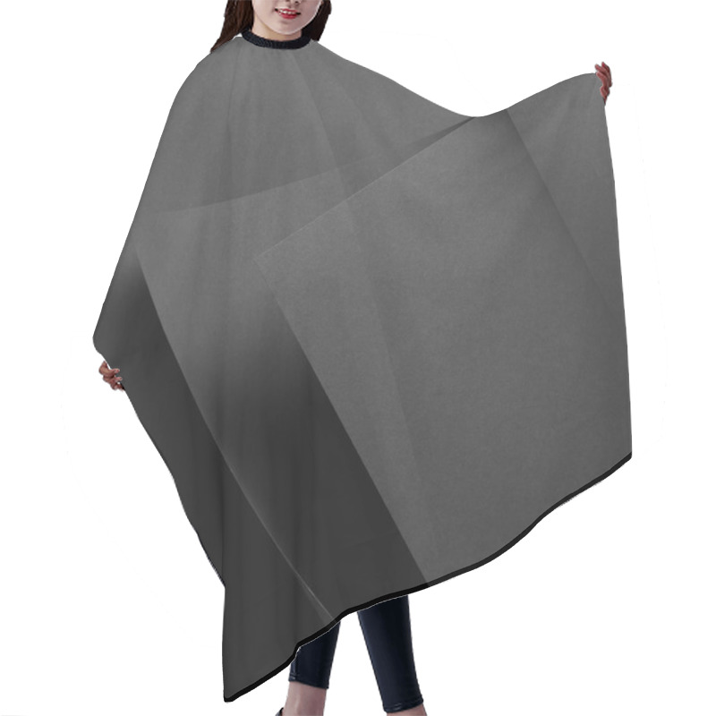 Personality  close-up view of grey paper sheet and dark background hair cutting cape