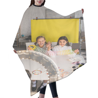 Personality  Cheerful Bloggers Talking And Showing Spiral Toy On Yellow Background In Front Of Blurred Digital Camera Hair Cutting Cape