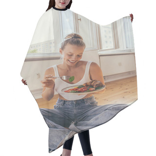Personality  Smiling Young Woman Holding Delicious Breakfast On Plate While Sitting On Floor At Home  Hair Cutting Cape