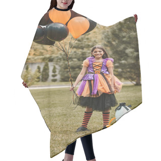 Personality  Happy Girl In Halloween Costume Holding Balloons Near Pumpkin, Pointed Hat And Candy Bucket On Grass Hair Cutting Cape