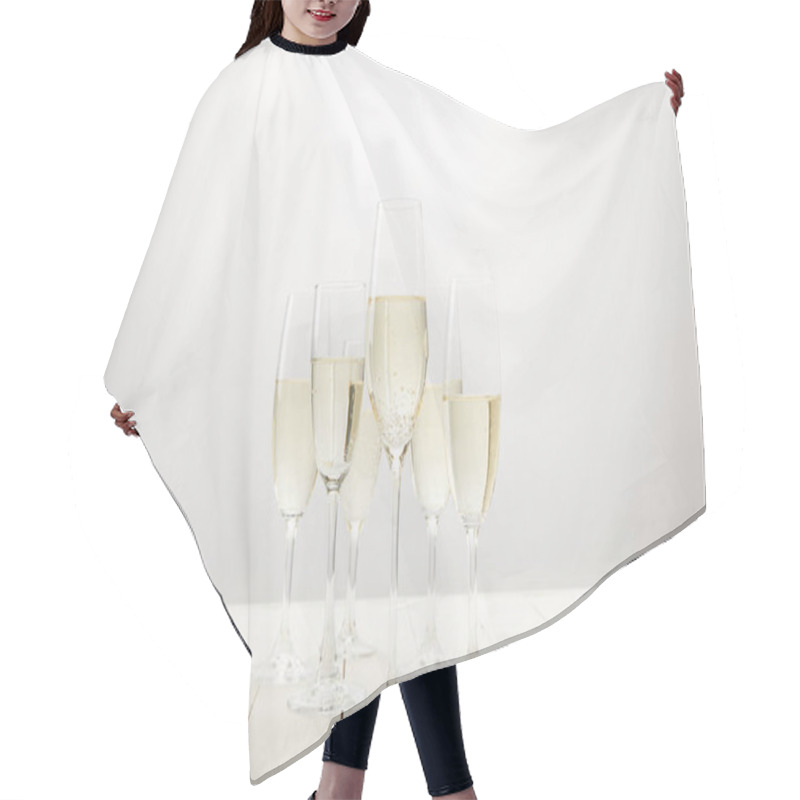 Personality  closeup view of champagne glasses on white wooden table  hair cutting cape