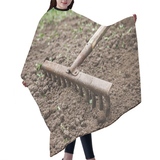 Personality  On The Soil Lie The Garden Rake. Close-up, Concept Of Gardening Hair Cutting Cape
