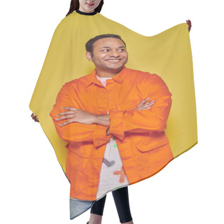 Personality  Portrait Of Positive Indian Man In Orange Jacket Standing With Folded Arms On Yellow Backdrop Hair Cutting Cape