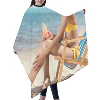 Personality  Cropped Image Of Woman Applying Sunscreen Lotion On Skin While Sitting On Deck Chair On Sandy Beach  Hair Cutting Cape
