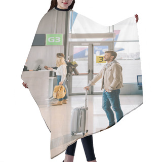 Personality  Side View Of Smiling Young Man Standing With Suitcase In Airport Hair Cutting Cape