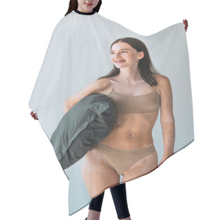 Personality  Happy Young Woman With Vitiligo And Braces Standing In Beige Lingerie And Holding Pillow Isolated On Grey Hair Cutting Cape