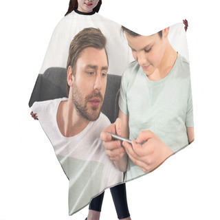 Personality  Curious Father Watching Son Using Smartphone In Living Room Hair Cutting Cape