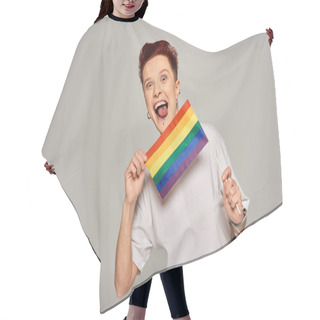 Personality  Excited Queer Model With Piercing Holding Small LGBT Flat And Sticking Out Tongue On Grey Backdrop Hair Cutting Cape