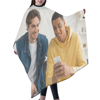 Personality  Interracial Friends Watching At Smartphone Together Sitting On Couch In Living Room Hair Cutting Cape