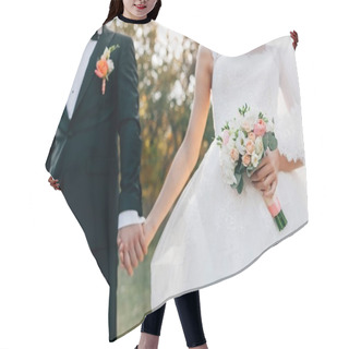 Personality  Wedding Bouquet. Blurred Bride With In A White Dress And Groom In Tuxedo Are Holding Hands. Soft Focus On Flowers. Outdoors Hair Cutting Cape