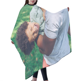 Personality  Cropped View Of African American Man Holding Laughing Son While Having Son In Park Hair Cutting Cape