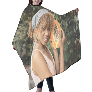 Personality  Pleased Young African American Woman With Braces Wearing Summer Dress And Headscarf Holding Fresh Papaya And Looking At Camera In Orangery, Stylish Lady Blending Fashion And Nature, Summer Concept Hair Cutting Cape