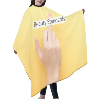 Personality  Cropped View Of Woman Showing Middle Finger And Card With Beauty Standards Lettering On Yellow Background  Hair Cutting Cape