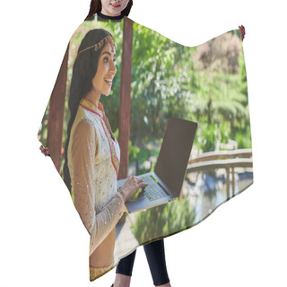 Personality  Summer Park, Smiling Indian Woman In Stylish Ethnic Wear Holding Laptop With Blank Screen Hair Cutting Cape