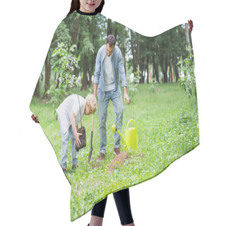 Personality  Son Planting Seedling In Ground Near Father In Park Hair Cutting Cape