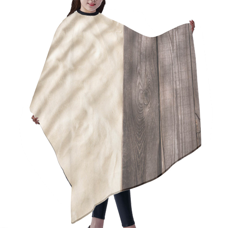 Personality  Top view of textured sand and wooden brown board with copy space hair cutting cape