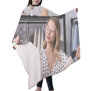 Personality  Joyful Successful Showroom Owner Holding Hangers With Clothes On Blurred Foreground Hair Cutting Cape