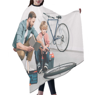 Personality  Man With Book Pointing By Hand At Bicycle Wheel To Little Son In Workshop  Hair Cutting Cape