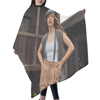 Personality  Stylish Brunette Woman In Vintage Outfit And Newsboy Cap Posing In Vest And Suspenders While Standing Near Rustic House In Rural Setting At Summer, Vintage-inspired Clothing Hair Cutting Cape
