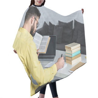 Personality  Bearded Man Studying With Book Near Laptop With Blank Screen In Modern Office Hair Cutting Cape