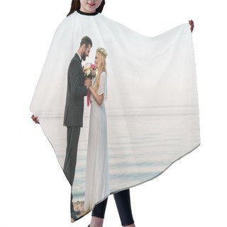 Personality  Side View Of Affectionate Wedding Couple Standing With Bouquet On Beach, Bride Sniffing Roses Hair Cutting Cape