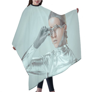 Personality  Futuristic Silver Cyborg Adjusting Eye Prosthesis And Looking At Camera Isolated On Grey, Future Technology Concept   Hair Cutting Cape