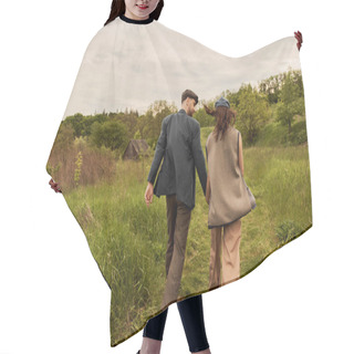 Personality  Bearded And Stylish Man In Jacket And Newsboy Cap Holding Hand And Looking At Brunette Girlfriend In Vest While Walking On Meadow With Nature At Background, Stylish Couple In Rural Setting Hair Cutting Cape