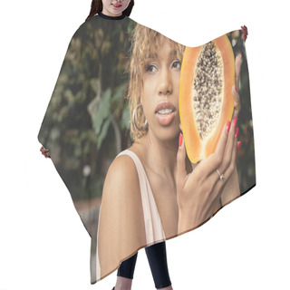 Personality  Confident Young African American Woman With Braces And Summer Outfit Holding Fresh And Ripe Papaya And Looking Away In Blurred Greenhouse, Stylish Lady Blending Fashion And Nature, Summer Concept Hair Cutting Cape