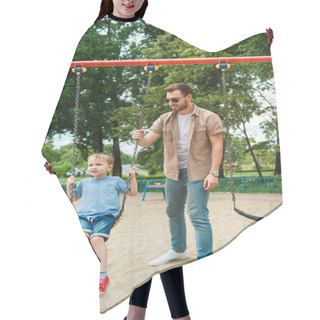 Personality  Dad And Son Having Fun On Swing At Playground In Park Hair Cutting Cape
