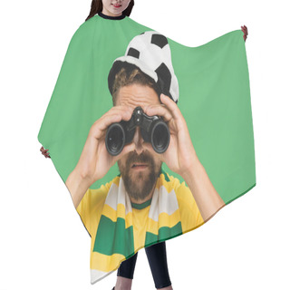 Personality  Bearded Man In Football Fan Hat And Striped Scarf Looking Through Binoculars During Match Isolated On Green  Hair Cutting Cape