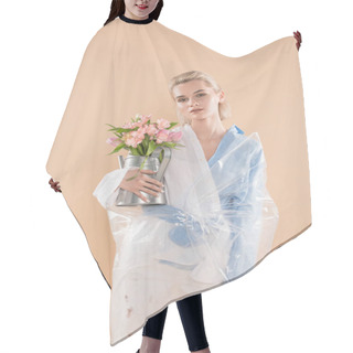 Personality  Attractive Girl Holding Watering Can With Flowers And Standing In Eco Clothing Wrapped In Polyethylene Isolated On Beige, Environmental Saving Concept  Hair Cutting Cape
