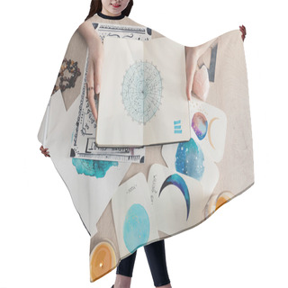 Personality  Top View Of Astrologer Holding Notebook With Watercolor Drawings And Zodiac Signs On Cards On Table  Hair Cutting Cape