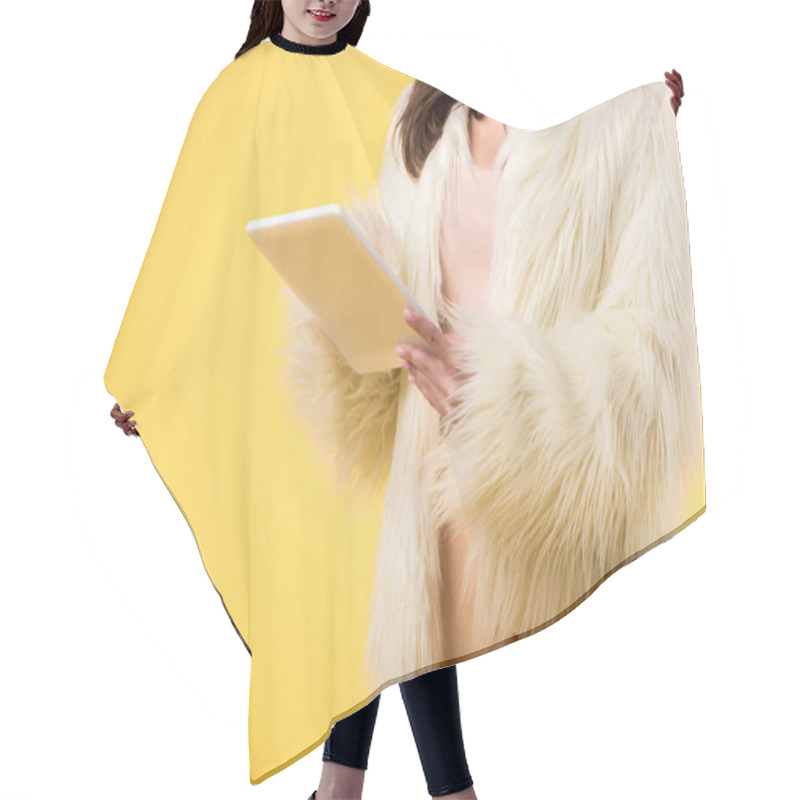 Personality  cropped view of elegant girl in faux fur jacket using digital tablet isolated on yellow hair cutting cape