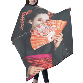 Personality  Geisha In Black Kimono With Red Flowers In Hair Hiding Face Behind Traditional Hand Fan Isolated On Black Hair Cutting Cape