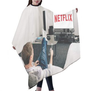 Personality  KYIV, UKRAINE - APRIL 14, 2020: Man In Jeans Holding Remote Controller Near Tv Screen With Netflix At Home  Hair Cutting Cape