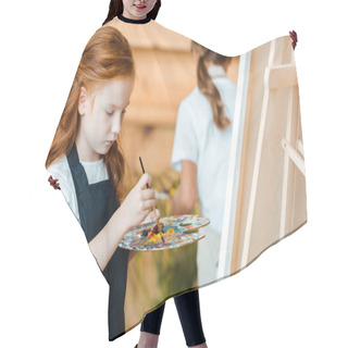 Personality  Selective Focus Of Cute Redhead Kid Painting In Art School Near Child Hair Cutting Cape