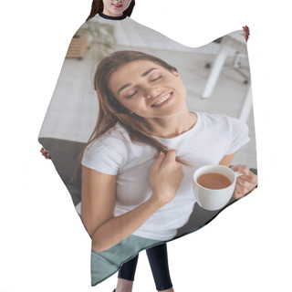 Personality  Young Woman Holding Cup With Tea While Chilling On Sofa In Living Room  Hair Cutting Cape
