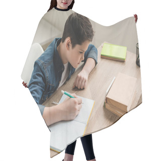 Personality  High Angle View Of Attentive Boy Writing In Copy Book While Doing Schoolwork At Home Hair Cutting Cape