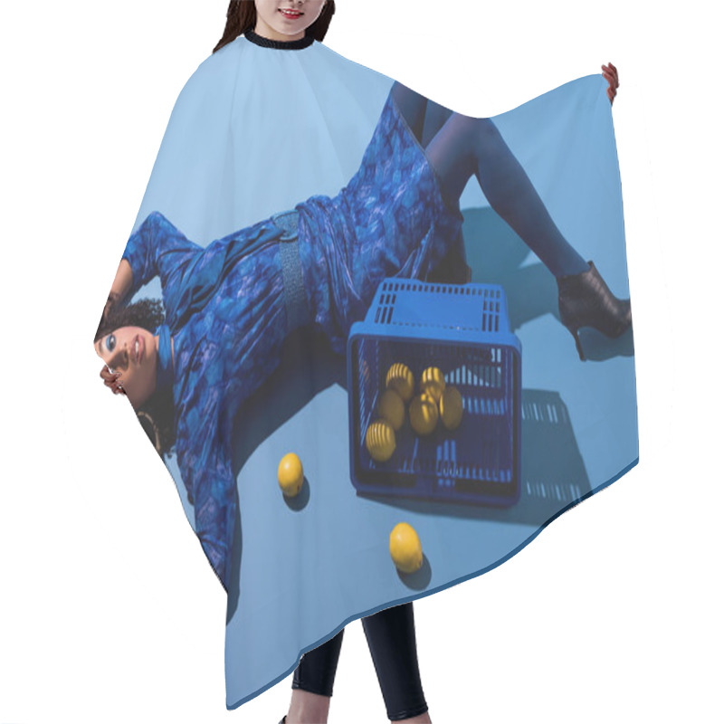 Personality  African American Woman Lying With Shopping Basket And Lemons On Blue Background  Hair Cutting Cape