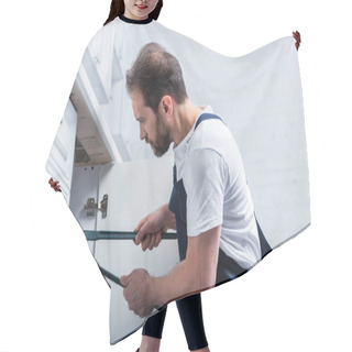 Personality  Side View Of Adult Bearded Repairman In Working Overall Fixing Sink With Pair Of Nippers In Kitchen  Hair Cutting Cape