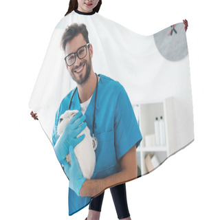 Personality  Handsome, Positive Veterinarian Smiling At Camera While Holding Cute Black And White Rabbit On Hands Hair Cutting Cape